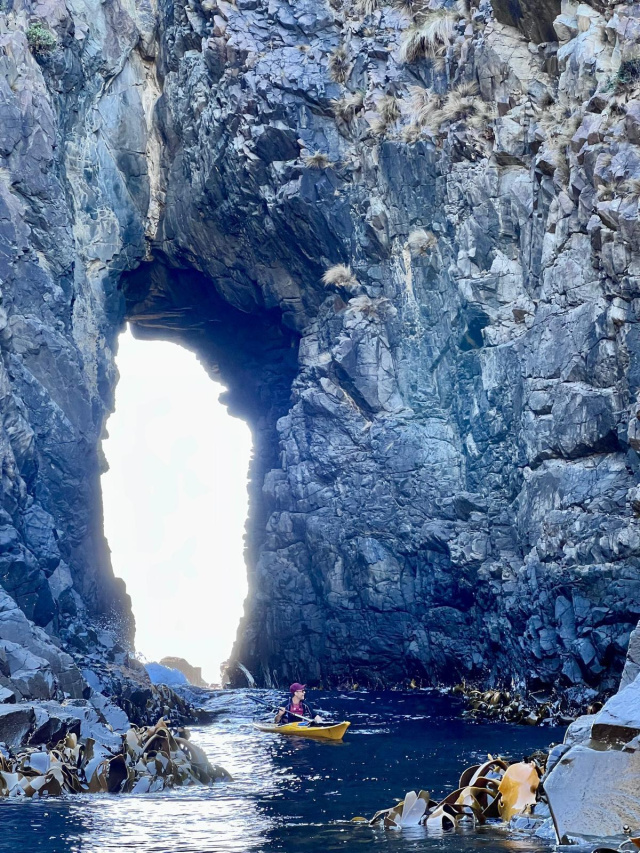 Kayaker through tunnel Bruny Sophie Ballagh